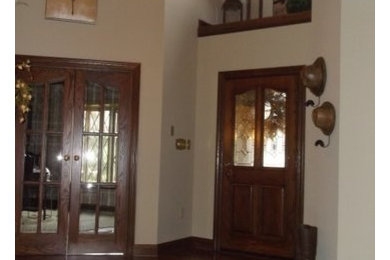 他の地域にある広いラスティックスタイルのおしゃれな玄関ロビー (ベージュの壁、濃色無垢フローリング、濃色木目調のドア) の写真