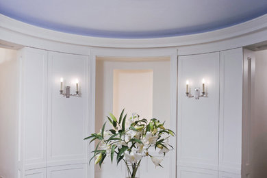 ニューヨークにあるラグジュアリーな広いトランジショナルスタイルのおしゃれな玄関ロビー (ライムストーンの床、白い壁) の写真