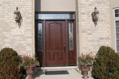 Mid-sized concrete floor entryway photo in Chicago with beige walls and a dark wood front door
