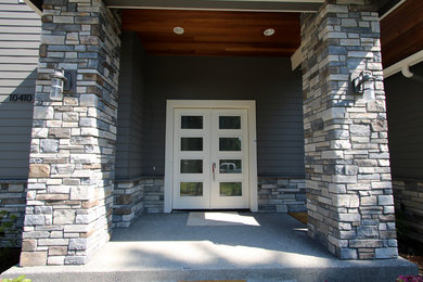 Ejemplo de puerta principal tradicional renovada pequeña con paredes grises, suelo de cemento, puerta doble, puerta blanca y suelo gris
