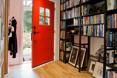 Diseño de hall actual pequeño con paredes blancas, suelo de madera clara, puerta simple y puerta roja