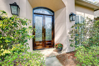 Photo of a large contemporary front door in New Orleans with a double front door and a dark wood front door.