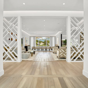 Aménagement d'un grand hall d'entrée contemporain avec un mur blanc, un sol en bois clair, une porte double, une porte en bois foncé, un sol beige et un plafond à caissons.