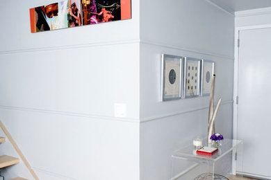 Inspiration för minimalistiska foajéer, med ljust trägolv och en vit dörr