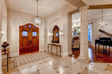 デンバーにあるラグジュアリーな巨大なトラディショナルスタイルのおしゃれな玄関ロビー (木目調のドア) の写真