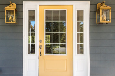 На фото: входная дверь среднего размера в стиле кантри с серыми стенами, одностворчатой входной дверью и желтой входной дверью с