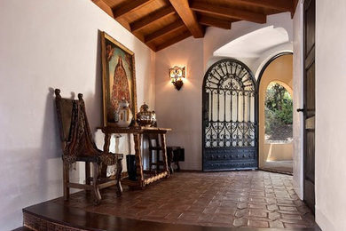 サンタバーバラにある地中海スタイルのおしゃれな玄関 (テラコッタタイルの床、金属製ドア) の写真