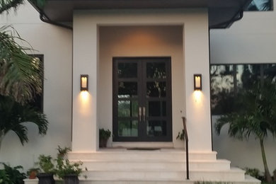Ejemplo de puerta principal minimalista grande con puerta doble y puerta metalizada
