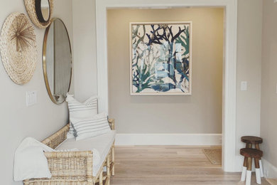 Example of a beach style light wood floor entryway design in Boston with gray walls