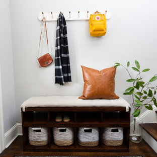 Example of a small transitional dark wood floor and brown floor entryway design in DC Metro with white walls and a white front door