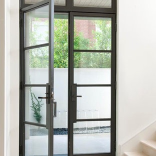 Immagine di un ingresso o corridoio minimal con una porta a due ante, una porta in vetro e pavimento bianco