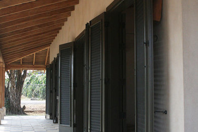 На фото: узкая прихожая в стиле фьюжн с бежевыми стенами и черной входной дверью с