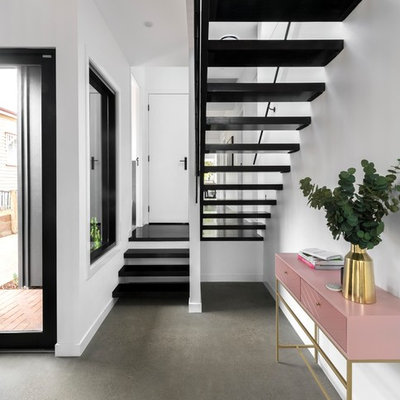 Trendy concrete floor and gray floor entryway photo in Brisbane with white walls and a white front door