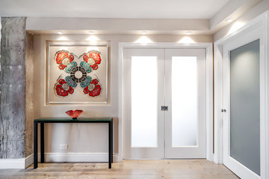 Mid-sized transitional light wood floor entryway photo in New York with gray walls and a glass front door