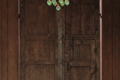 Ejemplo de puerta principal rural grande con paredes beige, suelo de ladrillo, puerta doble, puerta de madera oscura y suelo rojo