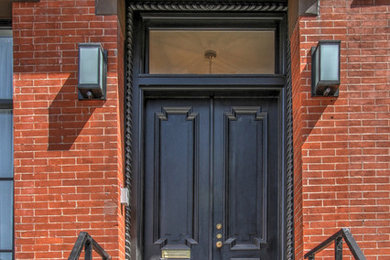 Elegant entryway photo in New York with a black front door