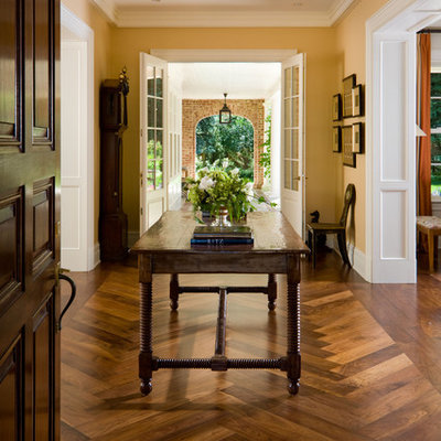 Inspiration for a timeless medium tone wood floor and brown floor entryway remodel in Denver with yellow walls and a glass front door