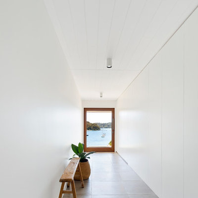 Inspiration for a contemporary gray floor entryway remodel in Sydney with white walls and a glass front door