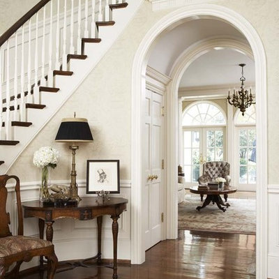 Inspiration for a large timeless medium tone wood floor foyer remodel in Other with beige walls