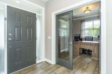 Inspiration for a mid-sized rustic laminate floor and gray floor entryway remodel in Vancouver with beige walls and a gray front door