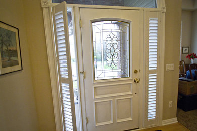 オマハにある中くらいなトラディショナルスタイルのおしゃれな玄関ドア (茶色い壁、淡色無垢フローリング、白いドア、茶色い床) の写真