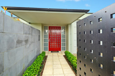 Inspiration för en mycket stor funkis ingång och ytterdörr, med betonggolv, en enkeldörr och en röd dörr
