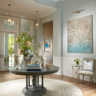 Inspiration pour un hall d'entrée ethnique avec un mur bleu et une porte en verre.