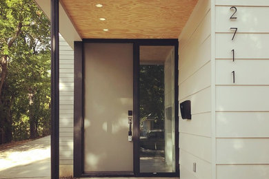 Idéer för att renovera en funkis ingång och ytterdörr, med vita väggar, betonggolv, en enkeldörr, en grön dörr och grått golv