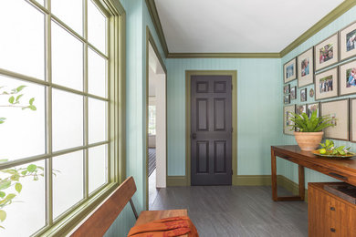 На фото: большое фойе в стиле неоклассика (современная классика) с синими стенами, полом из ламината, одностворчатой входной дверью, входной дверью из темного дерева и серым полом с