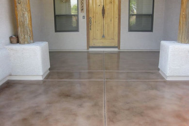 Example of a mid-sized concrete floor entryway design in Phoenix with white walls and a light wood front door