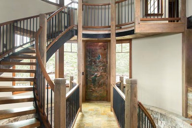 Mid-sized mountain style travertine floor, multicolored floor and wood ceiling entryway photo in Denver with beige walls and a metal front door