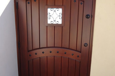 Свежая идея для дизайна: входная дверь среднего размера в средиземноморском стиле с одностворчатой входной дверью, входной дверью из дерева среднего тона и белыми стенами - отличное фото интерьера
