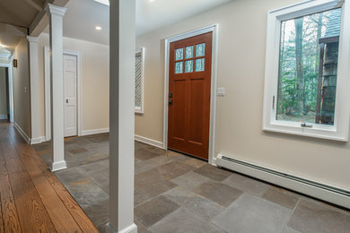 Exempel på en klassisk entré, med beige väggar, skiffergolv, en enkeldörr, mellanmörk trädörr och flerfärgat golv