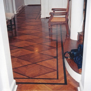 Esempio di un ingresso moderno di medie dimensioni con pareti bianche, pavimento in legno massello medio, una porta singola e una porta bianca
