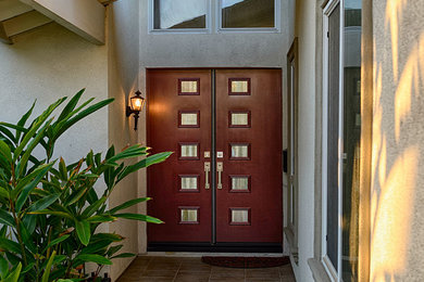 オレンジカウンティにある広いコンテンポラリースタイルのおしゃれな玄関ドア (グレーの壁、濃色木目調のドア) の写真