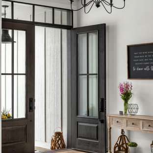 Foto di una porta d'ingresso country di medie dimensioni con pareti bianche, parquet chiaro, una porta a due ante, una porta grigia e soffitto a volta