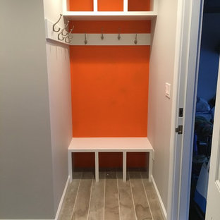 Kleiner Moderner Eingang mit Stauraum, oranger Wandfarbe und Porzellan-Bodenfliesen in New York