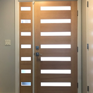 Ejemplo de puerta principal vintage, de tamaño medio, con paredes grises, suelo de madera en tonos medios, puerta simple y puerta de madera clara
