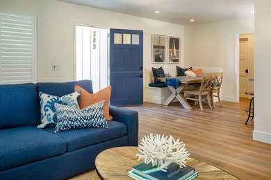 Entryway - large contemporary medium tone wood floor and brown floor entryway idea in Orange County with beige walls and a blue front door