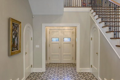 他の地域にあるトラディショナルスタイルのおしゃれな玄関ロビー (グレーの壁、白いドア、グレーの床) の写真