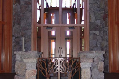 Example of a huge mountain style porcelain tile and brown floor entryway design in Other with multicolored walls and a glass front door