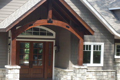 Ejemplo de entrada de estilo americano de tamaño medio con puerta doble y puerta de madera en tonos medios