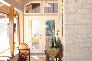Modelo de hall tradicional de tamaño medio con paredes blancas, suelo de madera clara, puerta blanca y puerta doble