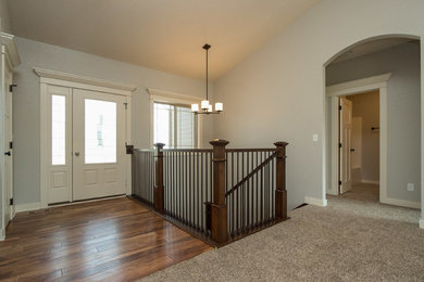 Mid-sized trendy medium tone wood floor entryway photo in Other with gray walls and a white front door