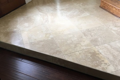 Example of a classic travertine floor and beige floor single front door design in Other with beige walls and a medium wood front door