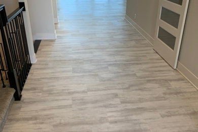 Example of a large minimalist vinyl floor and gray floor entryway design in Omaha with gray walls