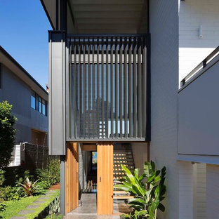 Large contemporary front door in Sydney with black walls, concrete floors, a single front door, a medium wood front door and grey floor.