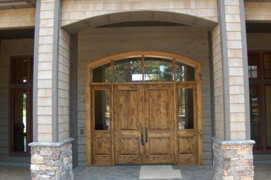 他の地域にある高級な広いラスティックスタイルのおしゃれな玄関ドア (木目調のドア) の写真