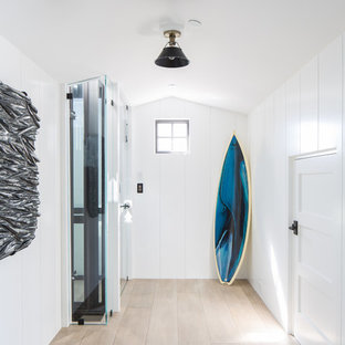 Foto de hall costero con paredes blancas, suelo de madera clara y suelo beige