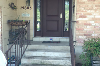 Mid-sized elegant concrete floor entryway photo in Austin with beige walls and a brown front door